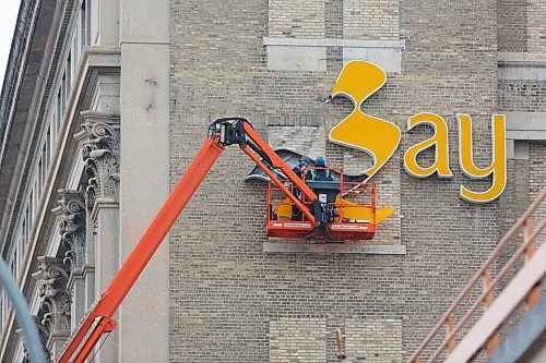 MIKE DEAL / WINNIPEG FREE PRESS
One of the signs that the Bay Downtown is gone is the removal of the logos adorning the building Friday morning.
201211 - Friday, December 11, 2020.