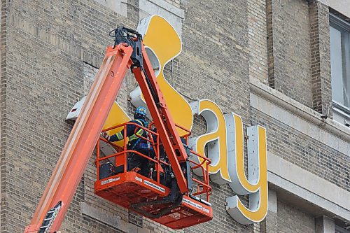 MIKE DEAL / WINNIPEG FREE PRESS
One of the signs that the Bay Downtown is gone is the removal of the logos adorning the building Friday morning.
201211 - Friday, December 11, 2020.