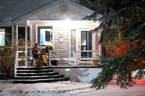 Daniel Crump / Winnipeg Free Press. Randy and Tracy Lennartz, of Bowhill Lane in Charleswood, sit on their porch with their dog Jager and enjoy a curb-side Christmas concert. The Christmas themed concert is part of a series masterminded by Dan Scramstad and Pierre Freyter as a way of spreading joy this holiday season. December 16, 2020.