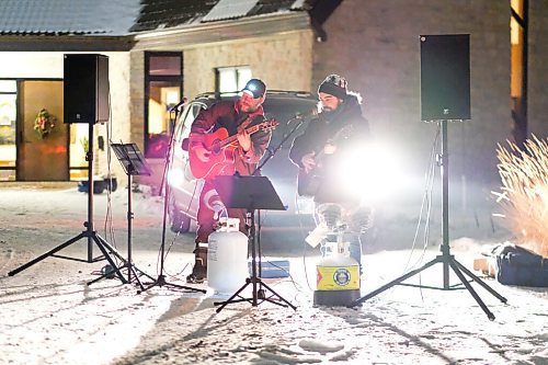 Daniel Crump / Winnipeg Free Press. Dan Scramstad (left) and Pierre Freyter (right) of Curbside Concerts sing at 40 Bowhill Lane, a cul-de-sac in Charleswood. Neighbours sat on their porches, or stood at the ends of their driveways, as the duo belted out classic Christmas carols. December 16, 2020.