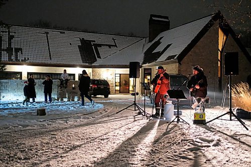 Daniel Crump / Winnipeg Free Press. Dan Scramstad (left) and Pierre Freyter (right) of Curbside Concerts sing at 40 Bowhill Lane, a cul-de-sac in Charleswood. Neighbours sat on their porches, or stood at the ends of their driveways, as the duo belted out classic Christmas carols. December 16, 2020.