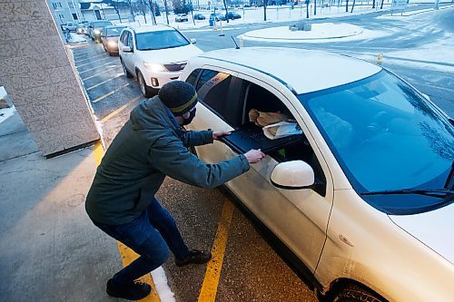 JOHN WOODS / WINNIPEG FREE PRESS
Steve Bock, director of outreach and missions at Grant Memorial Church serves up a COVID safe drive-through meal in Winnipeg Thursday, December 17, 2020. The church serves up to 450 meals.

Reporter: ?