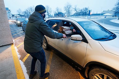 JOHN WOODS / WINNIPEG FREE PRESS
Steve Bock, director of outreach and missions at Grant Memorial Church serves up a COVID safe drive-through meal to Miranda Mortimore in Winnipeg Thursday, December 17, 2020. The church serves up to 450 meals.

Reporter: ?