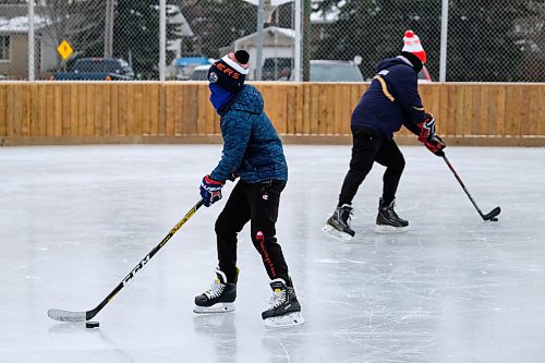 Daniel Crump / Winnipeg Free Press. Colson Hack (left) and Garner Hack skate on the rink at Roblin Park Community Centre during their ice time. Groups must preregister online to be able to use the ice. December 19, 2020.