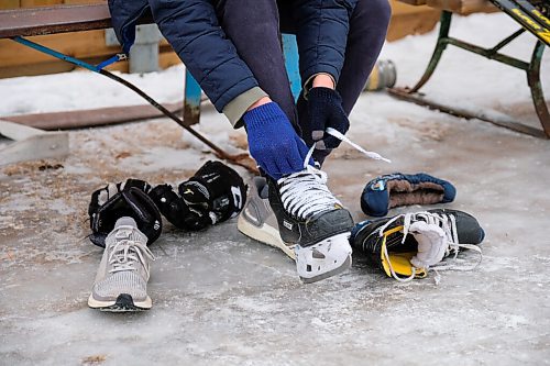 Daniel Crump / Winnipeg Free Press. Brady Hack puts on his skates in the area designated for his group. Groups must book ice time in advance to be able to skate at Roblin Park Community Centre. December 19, 2020.