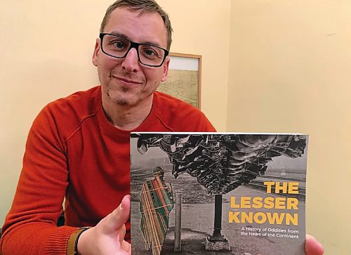 Canstar Community News Darren Bernhardt holds a copy of his new book The Lesser Known: A History of Oddities from the Heart of the Continent on Dec. 15. Bernhardt said he spent months scouring the citys archives for stories and photos