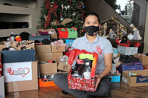 Canstar Community News Shiela Redublo sits amidst stacks of parcels in her living room on Dec. 15. The parcels are set to be delivered to people without homes on Christmas Day. (GABRIELLE PICHE/CANSTAR COMMUNITY NEWS/HEADLINER)
