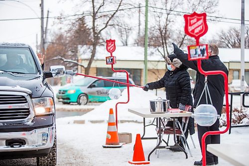 MIKAELA MACKENZIE / WINNIPEG FREE PRESS

Rosi Napady accepts a donation as Jamie Rands waves at a drive-in kettle fundraiser, the product of a collaboration between the Legion and the Salvation Army, takes place at the Charleswood Legion in Winnipeg on Tuesday, Dec. 22, 2020. 

Winnipeg Free Press 2020