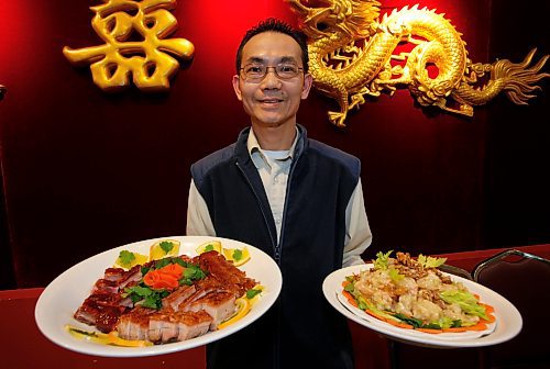 BORIS.MINKEVICH@FREEPRESS.MB.CA BORIS MINKEVICH/ WINNIPEG FREE PRESS  100112 Southland Restaurant manager Wai Kwok Ng with the Southland delux BBQ Platter (front), and the Pan Fried Shrimp with honey walnut dish.