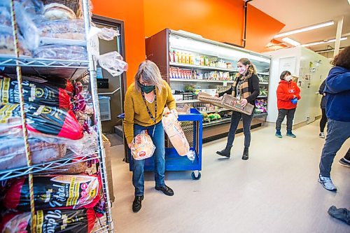 MIKAELA MACKENZIE / WINNIPEG FREE PRESS

Volunteer Kathy Turenne prepares for opening by stocking the bread shelf at the Essentials Market at the Main Street Project in Winnipeg on Thursday, Dec. 24, 2020. For --- story.

Winnipeg Free Press 2020