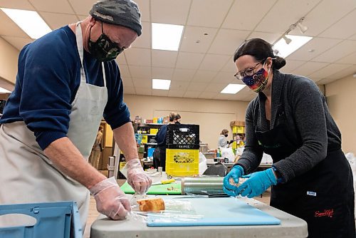 JESSE BOILY  / WINNIPEG FREE PRESS
John Sawatzky, left, and Jennifer Halwachs wrap up cakes to add to the Christmas dinners being handed out to those who need it on Christmas morning at Agape Table on Friday. Friday, Dec. 25, 2020.
Reporter: Malak Abas