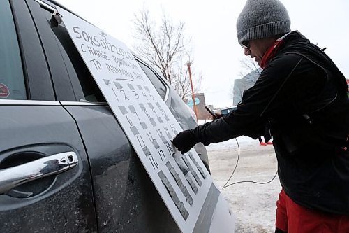 Daniel Crump / Winnipeg Free Press. Junel Malapad keeps track of his laps with an advent calendar style board. Each lap he completes he removes a piece of duct tape with a motivational message written on it from the board. December 26, 2020.