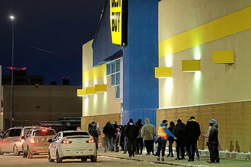 Daniel Crump / Winnipeg Free Press. A line of shoppers snakes along the parking lot at Best Buy Polo Park. December 26, 2020.