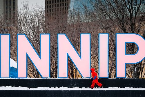 Daniel Crump / Winnipeg Free Press. A child in a red snowsuit plays in front of the WINNIPEG sign at the Forks on Saturday afternoon. December 26, 2020.