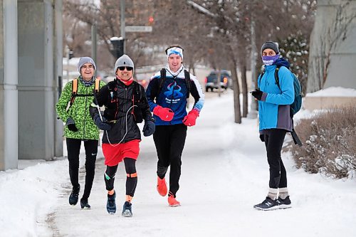 Daniel Crump / Winnipeg Free Press. Junel Malapad (red shorts) runs along Main Street flanked by friends Jonas Eastcott (left) and Dylan Peters (right). Malapad has done a 50km run every week for a year while raising money for different charities. December 26, 2020.