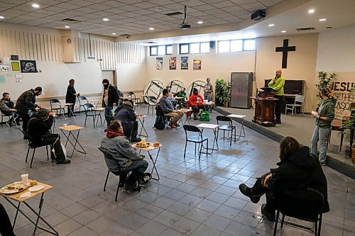 Daniel Crump / Winnipeg Free Press. People eat their holiday meal while a minister preaches to them at Union Gospel Mission. Tables are spaced two meters apart and each spot is sanitized before it is used again. January 2, 2021.