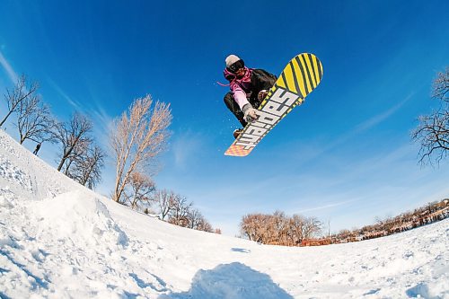 Daniel Crump / Winnipeg Free Press. Snowboarder Ethan Ginter hits a jump at Churchill Drive Park on a mild winter afternoon. January 2, 2021.