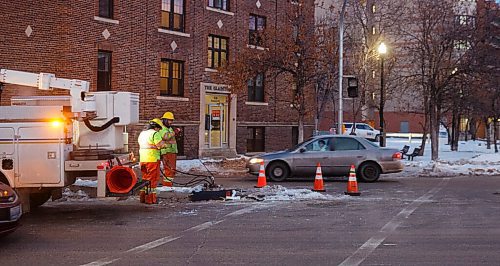 MIKE DEAL / WINNIPEG FREE PRESS
A city maintenance crew works on replacing the traffic lights at Ellice Avenue and Colony Street which was knocked down after a car crash. Traffic through the intersection was slow and being directed by cadets.
210105 - Tuesday, January 05, 2021.