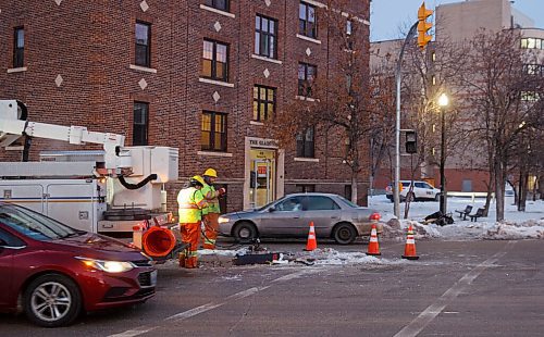 MIKE DEAL / WINNIPEG FREE PRESS
A city maintenance crew works on replacing the traffic lights at Ellice Avenue and Colony Street which was knocked down after a car crash. Traffic through the intersection was slow and being directed by cadets.
210105 - Tuesday, January 05, 2021.