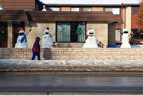 MIKE DEAL / WINNIPEG FREE PRESS
Mask wearing snowmen line Ness Avenue seeming to wave as a person walks by Wednesday afternoon. 
210113 - Wednesday, January 13, 2021