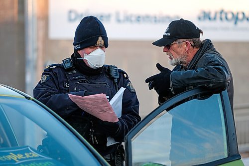 Daniel Crump / Winnipeg Free Press. RCMP issue a ticket to a man who spoke at the Hugs Over Masks protest in Steinbach. January 16, 2021.