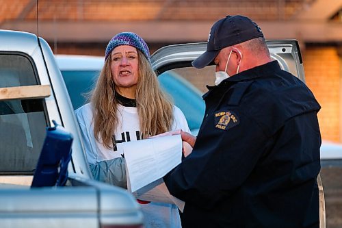 Daniel Crump / Winnipeg Free Press. RCMP issue a ticket to an organizer of the Hugs Over Masks protest in Steinbach. January 16, 2021.