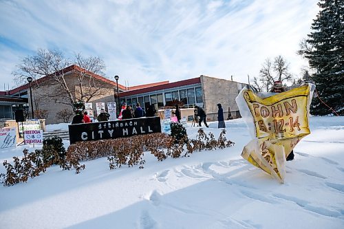 Daniel Crump / Winnipeg Free Press. A protestor holds up a sign with bible verses on it during an anti-mask protest organized by the group Hugs Over Masks outside city hall in Steinbach, Manitoba. January 16, 2021.