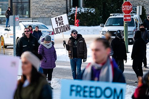 Daniel Crump / Winnipeg Free Press. A protestor holds a sign that reads end the lockdown at a protest organized by the group Hugs Over Masks outside city hall in Steinbach, Manitoba. January 16, 2021.