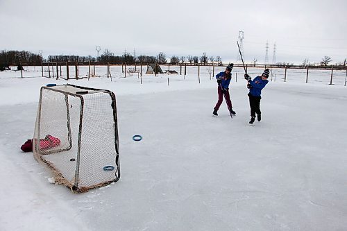 Canstar Community News Olivia Miller, left, and her twin sister Josie gear up for the Keira's Winter Klassic 12-day shooting challenge on their backyard rink on Jan. 20. (GABRIELLE PICHÉ/CANSTAR COMMUNITY NEWS/HEADLINER)