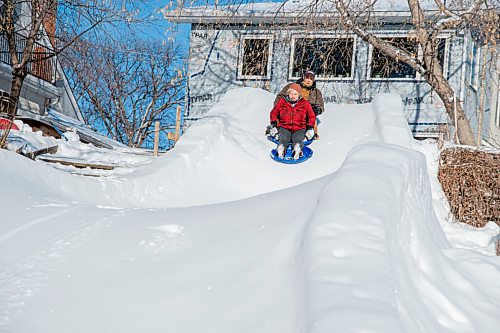 MIKE SUDOMA / WINNIPEG FREE PRESS
Rob Dorbolo, Marlies Dyck take a slide down a toboggan run they built in front of their property along the Assiniboine River Sunday morning. 
January 24, 2021