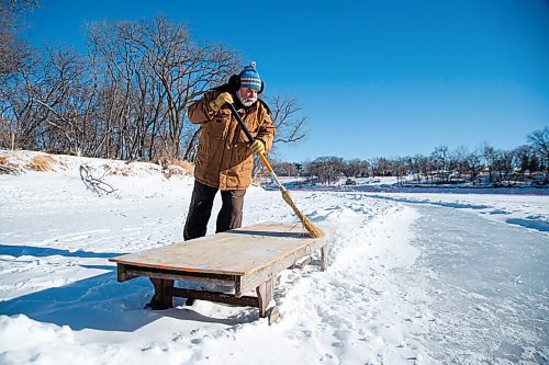 MIKE SUDOMA / WINNIPEG FREE PRESS
Local resident, Ron Gilfillan, sweeps off a bench he had made which now sits along the Assiniboine River trail
January 24, 2021