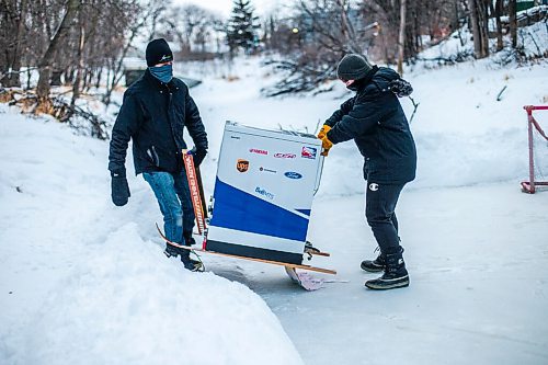 MIKAELA MACKENZIE / WINNIPEG FREE PRESS

Ron (left) and Anthony Thierault lift their washing machine zamboni up off of the Seine River near Marion Street in Winnipeg on Monday, Jan. 25, 2021. For JS story.

Winnipeg Free Press 2021