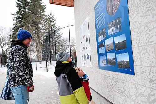 Daniel Crump / Winnipeg Free Press. Jenny Sendall (left) and her sons Bauer (middle) and Bennett (right) check out a sign that has information about wolves during their visit the the Winnipeg Zoo. The zoo has been granted permission to reopen and is required to follow strict precautions to help precent the spread of COVID-19. January 30, 2021.