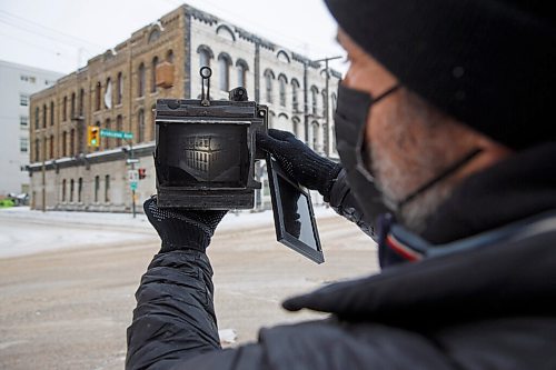 MIKE DEAL / WINNIPEG FREE PRESS
Keith Levit with his large format 4x5 camera takes some photos of street scene's in Winnipeg's Downtown Thursday afternoon.
Keith Levits camera collection is over 100 strong, with some as old as 105 years. During the pandemic, hes dusted them off, found old film in a closet and in his freezer, and walked around the city capturing the years 2020 and 2021 through lenses that have witnessed bygone eras. Hes so far shot with 43 of 100, with many cameras acquired from the personal collection of famed Winnipeg photographer Barney Charach, and many more purchased at antique and curiosity shops in places like St. Petersburg. 
210204 - Thursday, February 04, 2021.