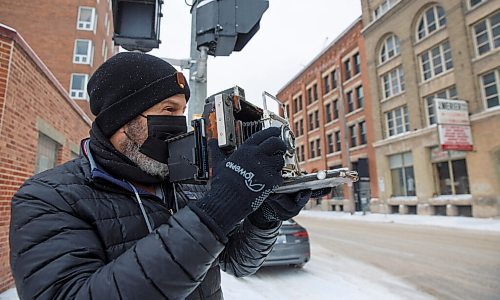 MIKE DEAL / WINNIPEG FREE PRESS
Keith Levit with his large format 4x5 camera takes some photos of street scene's in Winnipeg's Downtown Thursday afternoon.
Keith Levits camera collection is over 100 strong, with some as old as 105 years. During the pandemic, hes dusted them off, found old film in a closet and in his freezer, and walked around the city capturing the years 2020 and 2021 through lenses that have witnessed bygone eras. Hes so far shot with 43 of 100, with many cameras acquired from the personal collection of famed Winnipeg photographer Barney Charach, and many more purchased at antique and curiosity shops in places like St. Petersburg. 
210204 - Thursday, February 04, 2021.