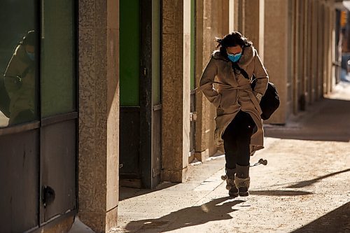 MIKE DEAL / WINNIPEG FREE PRESS
Masked pedestrians make their way along Donald Street during a -32C cold snap Monday morning.
210208 - Monday, February 08, 2021.