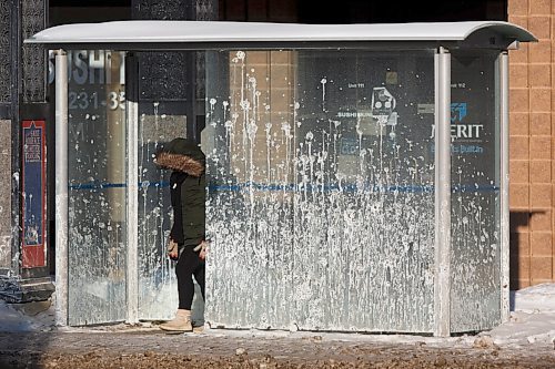 MIKE DEAL / WINNIPEG FREE PRESS
Trying to protect themselves during an extreme cold warning a person waits in a mud splattered shelter for a bus Wednesday morning on Provencher Blvd.
210210 - Wednesday, February 10, 2021.