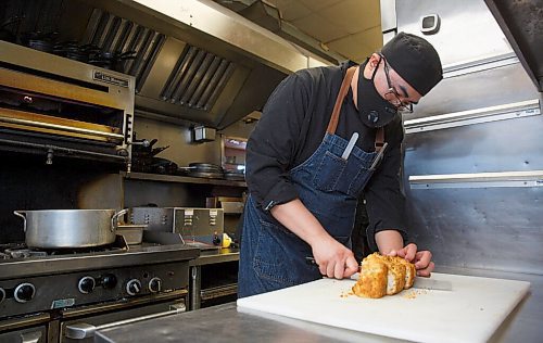 MIKE DEAL / WINNIPEG FREE PRESS
Kevin Chen, Chef at Promenade Cafe and Wine (130 Provencher Blvd) slices some bannock in the kitchen. 
210211 - Thursday, February 11, 2021.