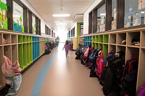 MIKE SUDOMA / WINNIPEG FREE PRESS
A young student walks down an empty hallway lined with childrens winter wear inside Templeton School Thursday afternoon
February 11, 2021