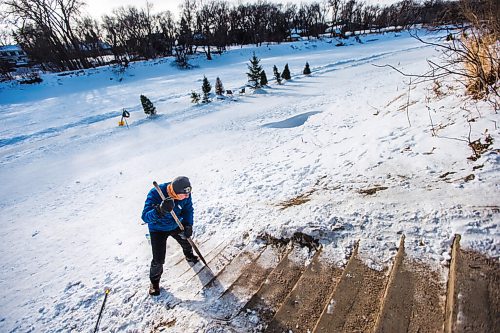 MIKAELA MACKENZIE / WINNIPEG FREE PRESS

Michael Bennett, who's organizing a fundraiser to get people to shovel and maintain river access points in Wolseley, chips the snow off the steps at the Aubrey access point to the river trail in Winnipeg on Friday, Feb. 12, 2021. For Katie story.

Winnipeg Free Press 2021