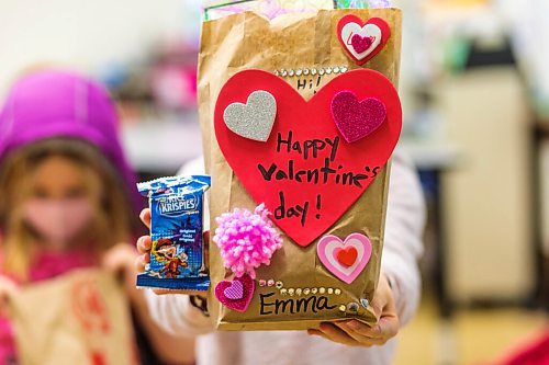 MIKAELA MACKENZIE / WINNIPEG FREE PRESS

Emma Wiehler (seven) holds up her brown bag full of valentines at Wolseley School in Winnipeg on Friday, Feb. 12, 2021. Students at Wolseley School were asked to bring in their cards and drop them into classmates' brown bags on Tuesday, so the cards could isolate for 72 hours. For Maggie story.

Winnipeg Free Press 2021