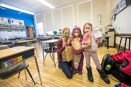 MIKAELA MACKENZIE / WINNIPEG FREE PRESS

Vanessa Wiehler, a grade 5-6 teacher (left), and her daughters, Heidi (four) and Emma (seven), pose for a photo with their brown bags full of valentines at Wolseley School in Winnipeg on Friday, Feb. 12, 2021. Students at Wolseley School were asked to bring in their cards and drop them into classmates' brown bags on Tuesday, so the cards could isolate for 72 hours. For Maggie story.

Winnipeg Free Press 2021