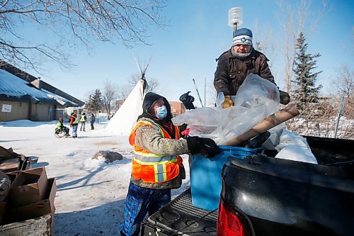 JOHN WOODS / WINNIPEG FREE PRESS
Volunteers Ray, left, and EJ move garbage at the Anishinative camp at Thunderbird House in Winnipeg Sunday, February 14, 2021.

Reporter: Sellar