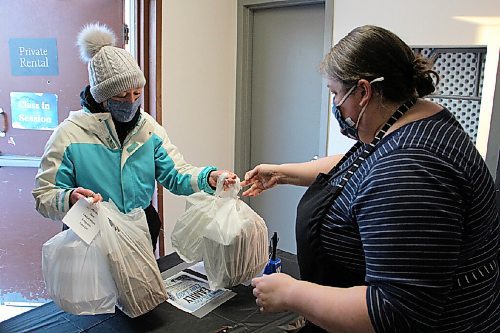 Canstar Community News Christine Aquin, left, picks up spaghetti dinner for her family during Winter Family Fun Day on Feb. 6. Cheryl Stock, right, passes along the food she cooked for the event. (GABRIELLE PICHÉ/CANSTAR COMMUNITY NEWS/HEADLINER)