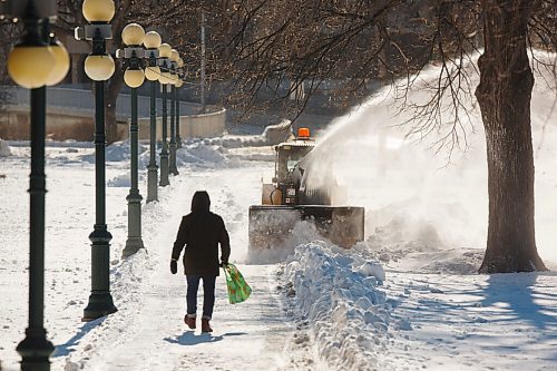 MIKE DEAL / WINNIPEG FREE PRESS
A pedestrian walks towards a snowblower making a wider path on the grounds the Manitoba Legislative building Tuesday afternoon. 
210216 - Tuesday, February 16, 2021.