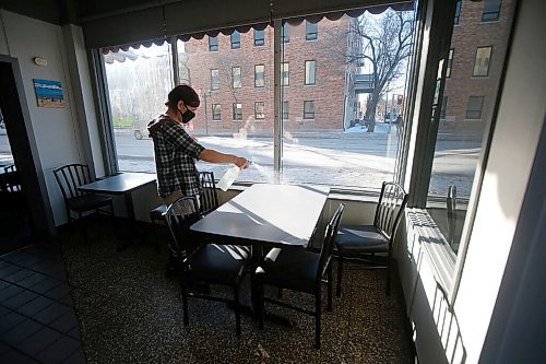 JOHN WOODS / WINNIPEG FREE PRESS
Prin Roussin, a server at The Nook restaurant in Winnipeg, cleans a table after a customer finished their meal Tuesday, February 16, 2021. Manitobas new COVID-19 restrictions allow for 25% occupancy in restaurants, but customers sitting at the same table must be from the same residence.

Reporter: Abas