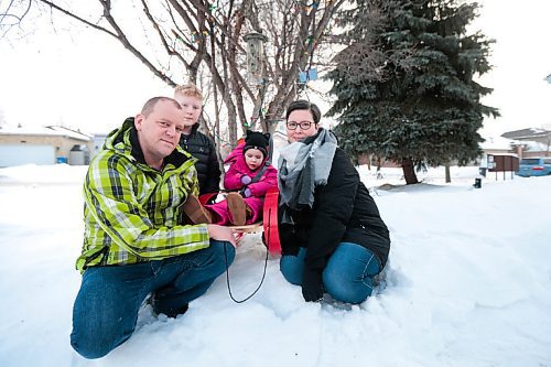 MIKAELA MACKENZIE / WINNIPEG FREE PRESS

John (left), Everett, Kyrie, and Tammy Brinkman pose for a photo in their front yard in Winnipeg on Thursday, Feb. 18, 2021. Four-year-old Kyrie volunteers her time as the ambassador for the Children's Rehabilitation Foundation (and is sitting in a support seat provided by the foundation).  For Aaron Epp story.

Winnipeg Free Press 2021