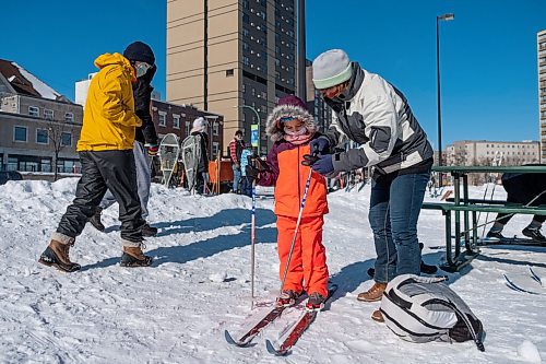 Daniel Crump / Winnipeg Free Press. Zaleeah Snowden Haas tries out cross country skis for the first time with the help of her grandmother, Christine Haas. The skis are borrowed from the mobile ski library which was set up at Central Park for the Heart in the Park event. February 20, 2021.