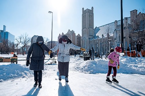 Daniel Crump / Winnipeg Free Press. Aisha Mohamed (middle) is helped on the ice by a volunteer at Heart in the Park in Central Park. This is only Aishas second time on skates.. February 20, 2021.