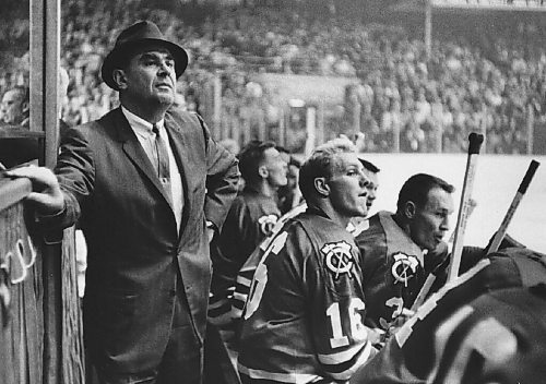 Canstar Community News Weston's Rudy Pilous is shown coaching the Chicago Black Hawks in this undated photo. Bobby Hull (wearing number 16, with which he started his NHL career) sits on the bench in front of him, beside Pierre Pilote.